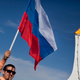Un hombre sostiene la bandera rusa en Sochi en 2014. Imagen: AP